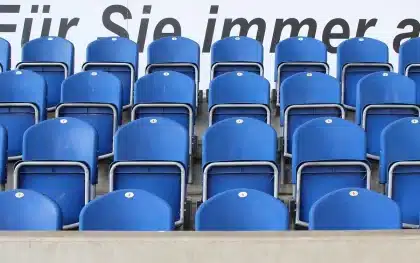 Empty stadium concourse with a discarded scarf and a crumpled ticket