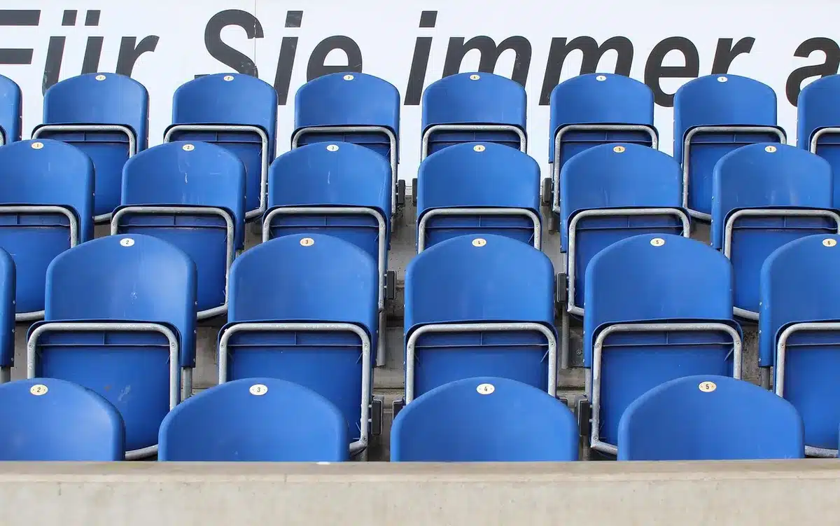 Empty stadium concourse with a discarded scarf and a crumpled ticket