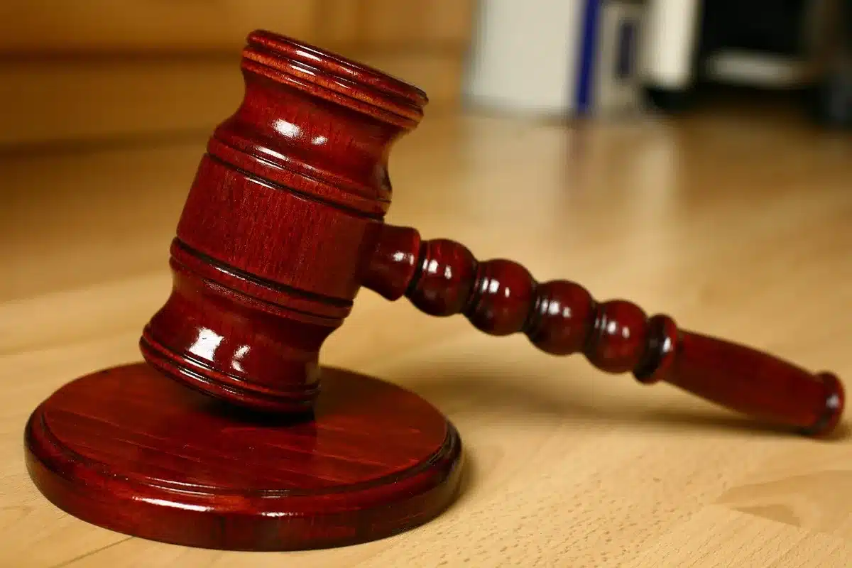 Court folder and legal papers on a wood table in a courthouse context