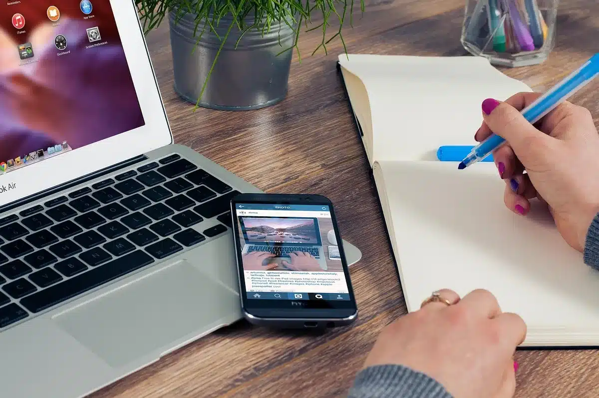 Person reviewing an email on a laptop screen with a phone nearby