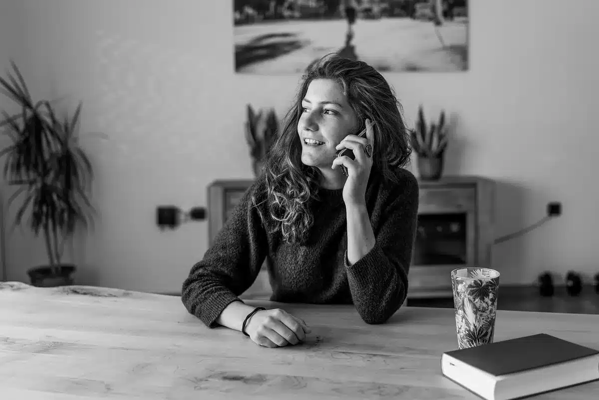 Anonymous woman on a phone in a living room, emotional and contemplative