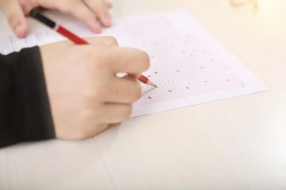 Hands using a tablet at a conference table with blurred whiteboard and documents