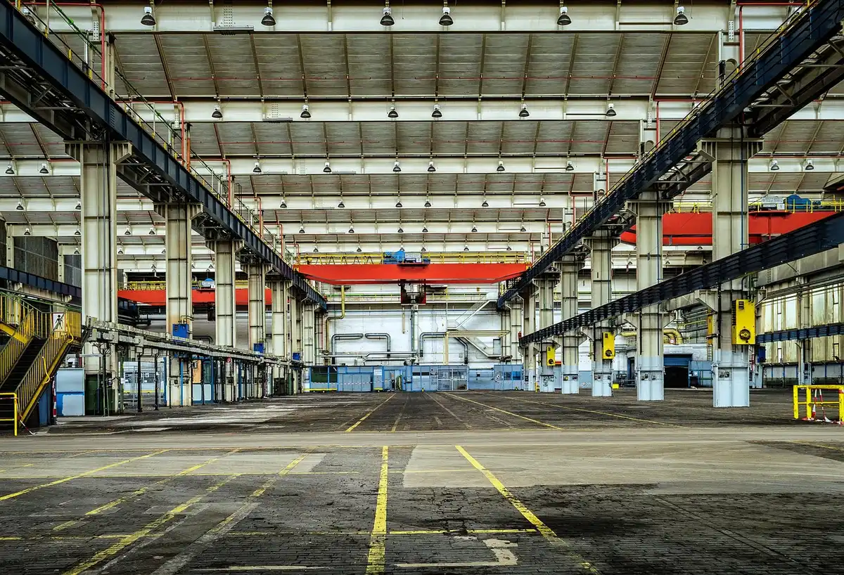 Interior of a large car factory with assembly line and vehicles in production