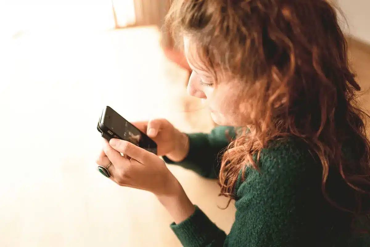 Hand holding phone scrolling an Instagram feed of friends at brunch