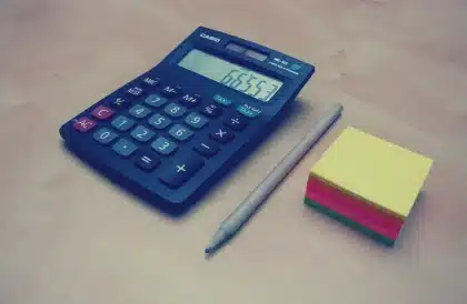 Mortgage documents and calculator on a desk showing rising interest rates