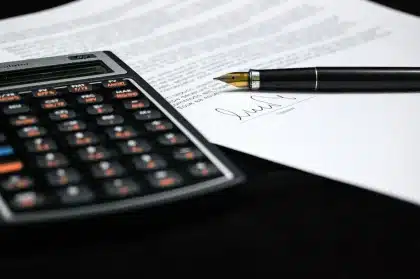 Pharmaceutical executives and government officials reviewing drug pricing agreement documents at a negotiation table