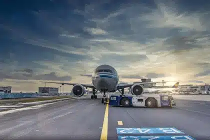Empty jetway with suitcase on tarmac outside a terminal, travel concept