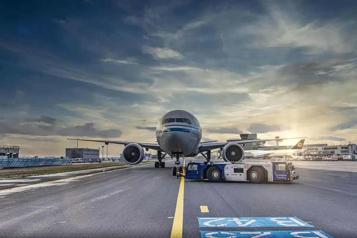 Empty jetway with suitcase on tarmac outside a terminal, travel concept