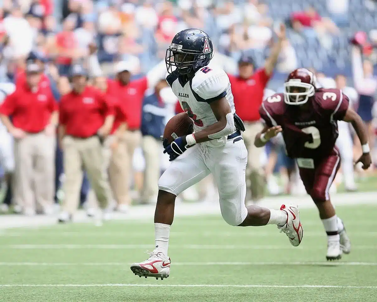 David Montgomery running with the ball in an NFL game, showing follow-through and contact