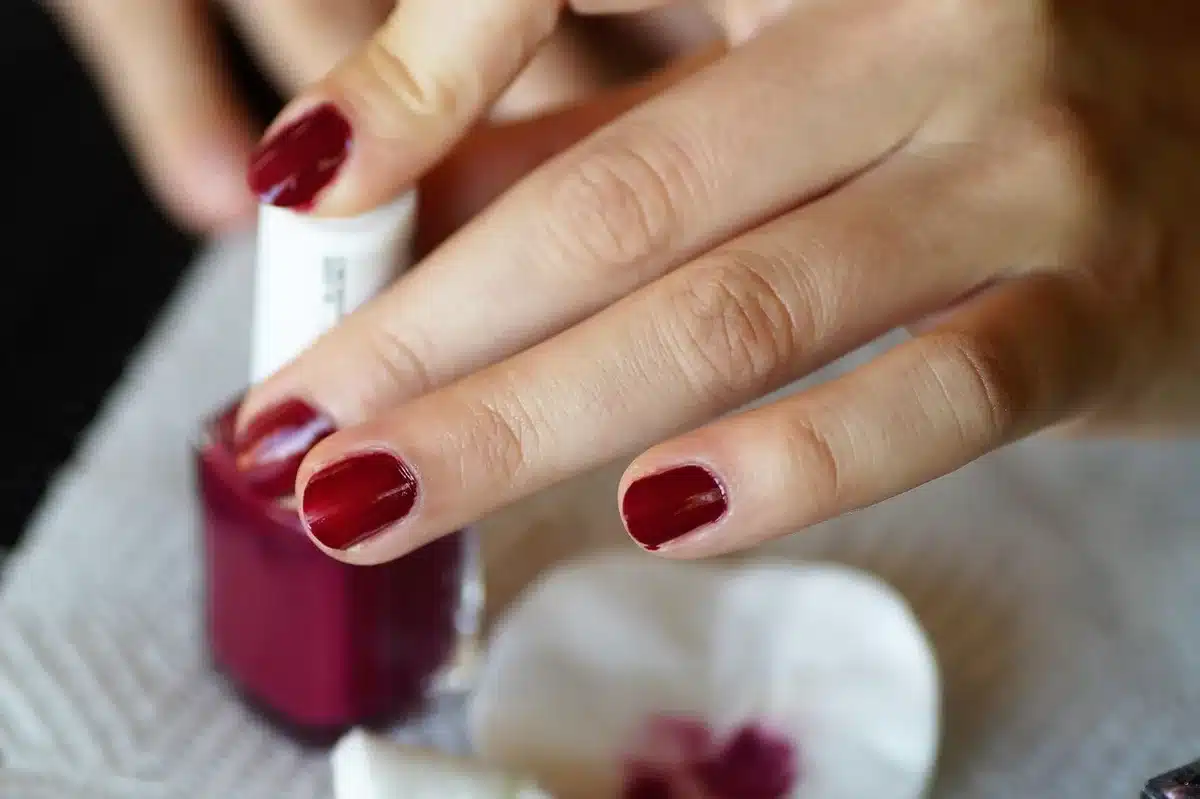 Close-up of a nail technician applying polish during a manicure tutorial