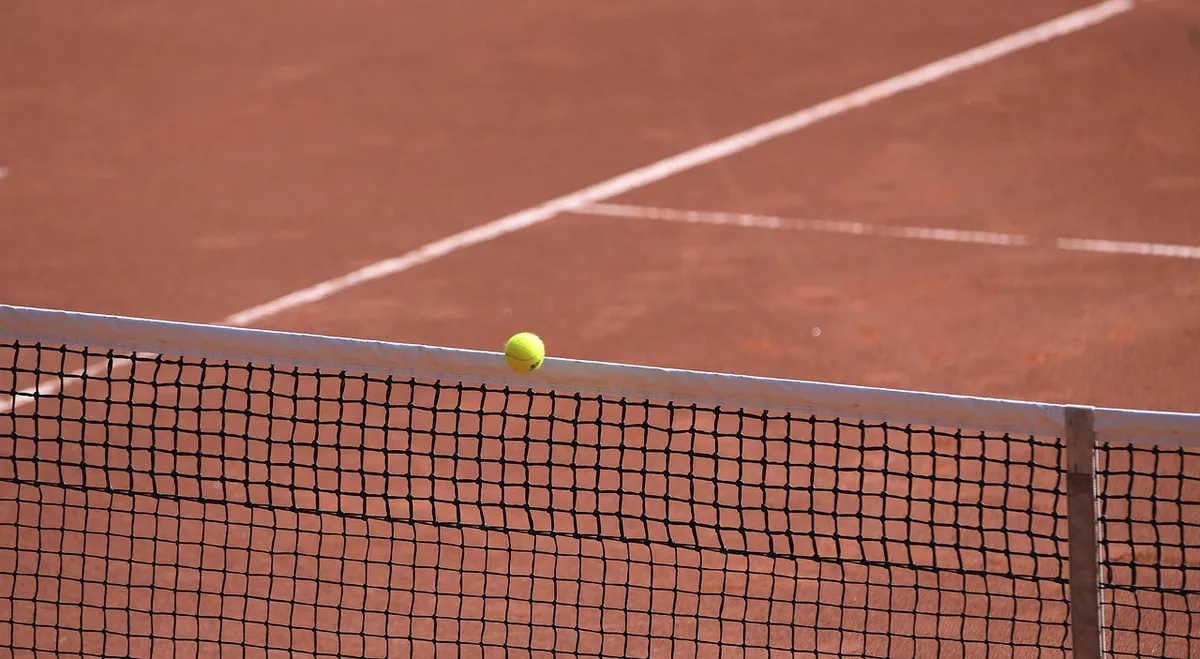 Tennis court close-up showing perimeter advertising lights near baseline