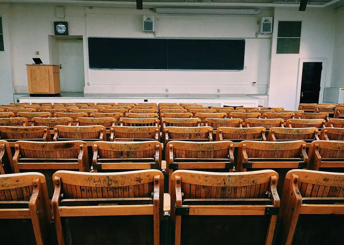 Salle de classe vide avec chaises déplacées et toilettes hors service
