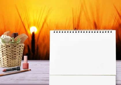 February calendar beside an analog clock and a small lunar calendar on a desk