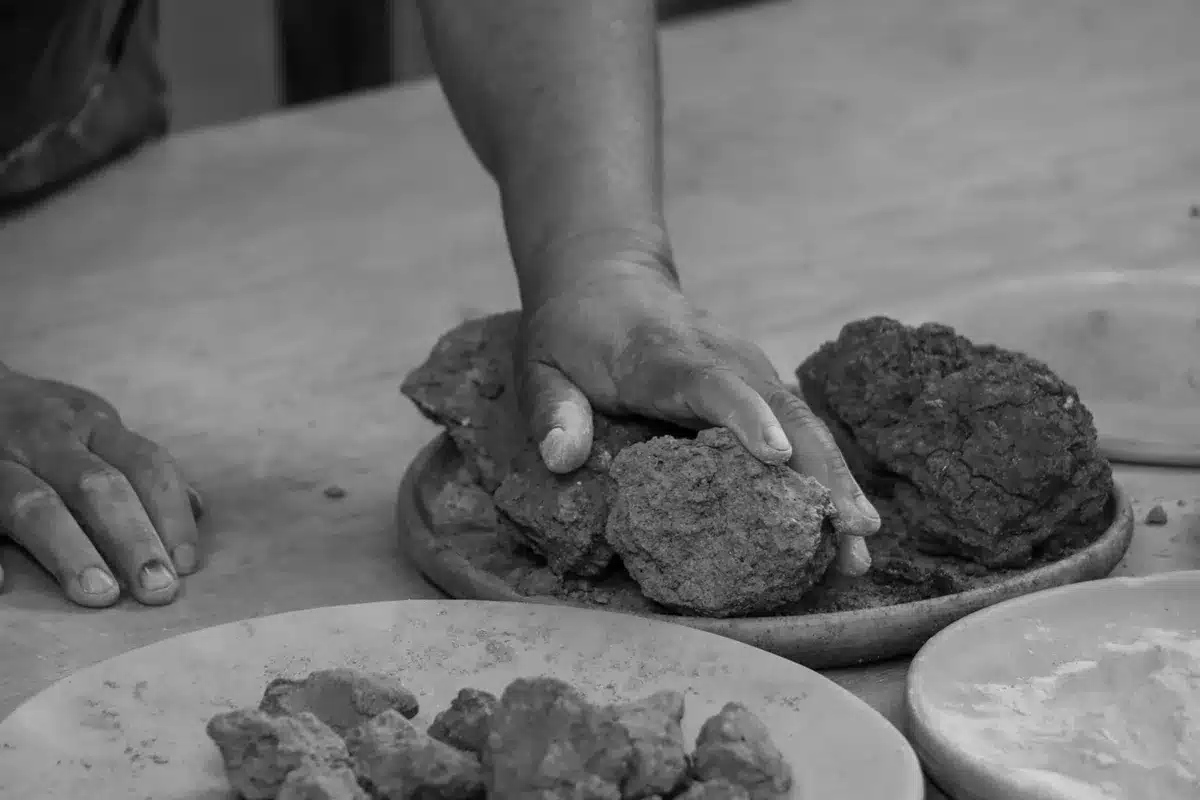 Archaeologists' hands holding a small clay tablet fragment at a dig site in Anatolia