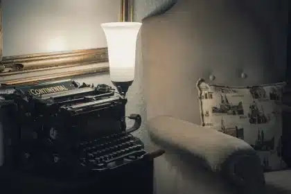 Quill and folded letter on a dressing table with blurred figures in background