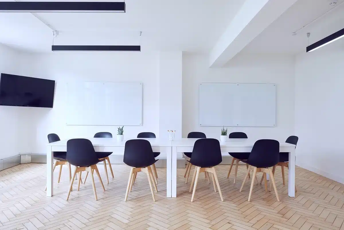 Executives exchanging documents and handshake in a boardroom during takeover talks