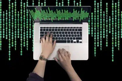 Anonymous laptops and hands around a table with blurred forum posts and code visible on screens