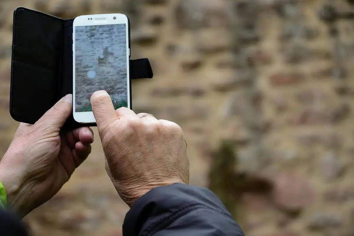 Rugged smartphone on a workbench with a small detachable camera module beside it