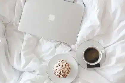 Hands with a remote and a laptop showing viewing graphs on a coffee table