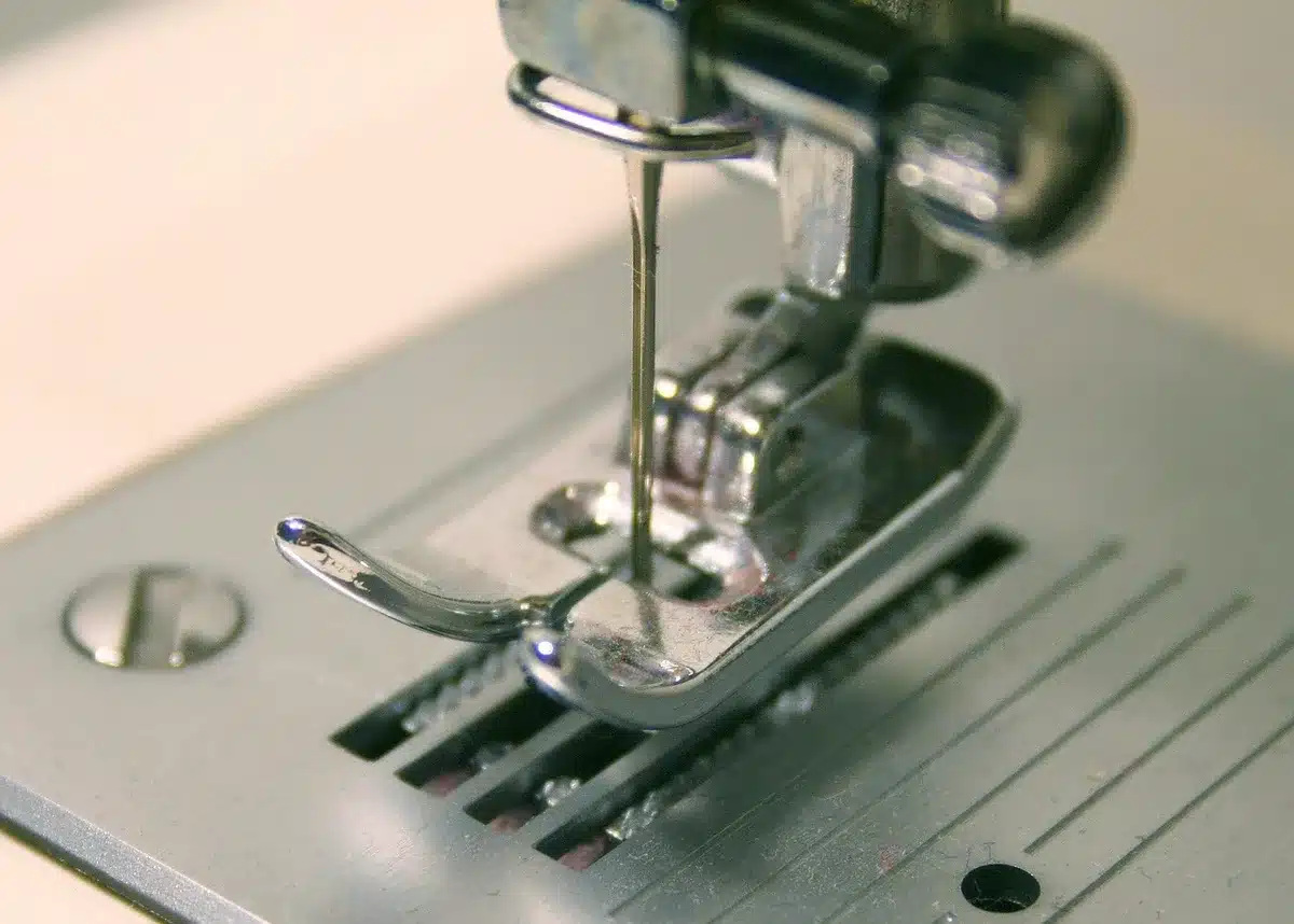 Hands mending a hem with needle and thread